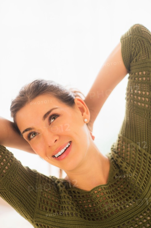 Woman with hands behind head