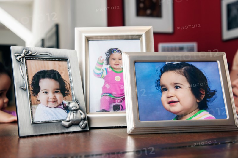 Children's (6-11 months) portraits in frames on table