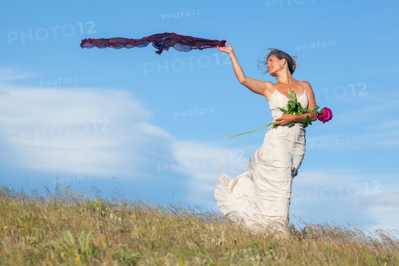 Bride standing in meadow