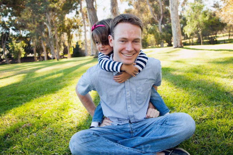 Daughter (4-5 years) embracing her father in park