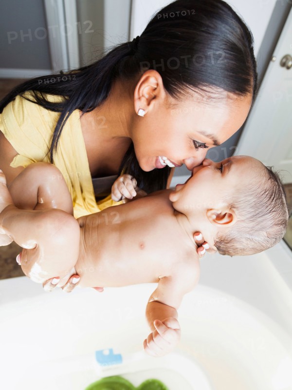 Mother giving her son (2-5 months) a bath