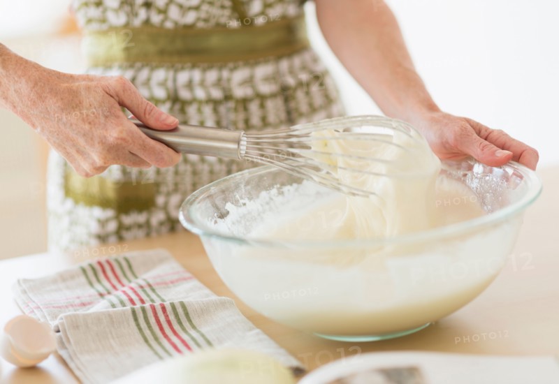 Midsection of woman whisking batter.