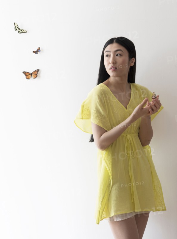 Studio shot of woman looking at butterflies.