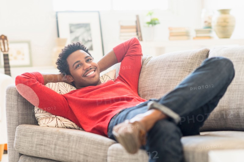 Man lying on sofa and smiling.