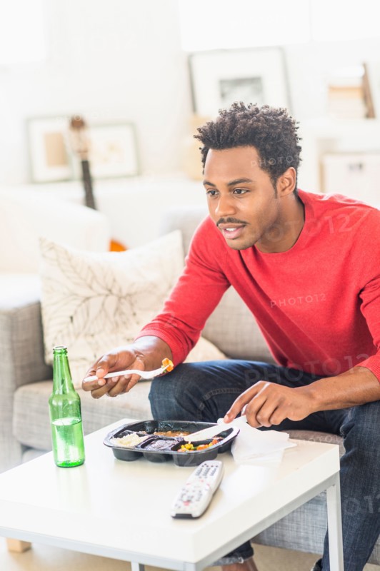 Man eating dinner and watching television.