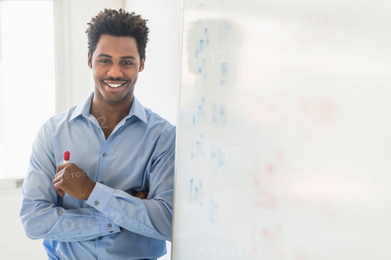 Businessman writing on whiteboard.