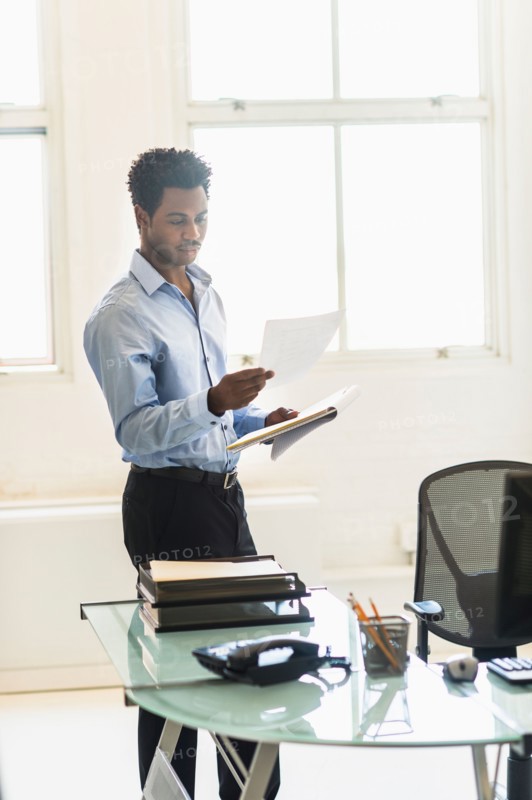 Businessman reading documents in office.