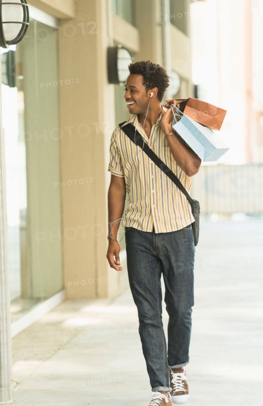Man walking on street with shopping bags.