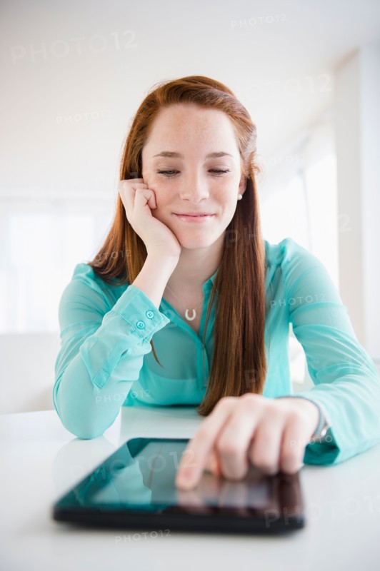 Teenage girl (14-15) using digital tablet