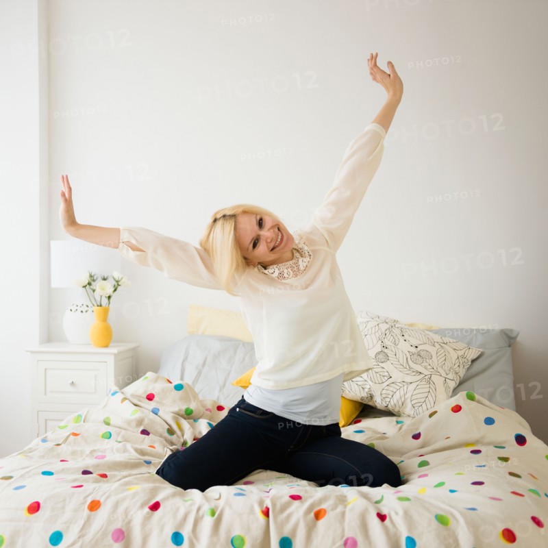Young woman stretching in bed