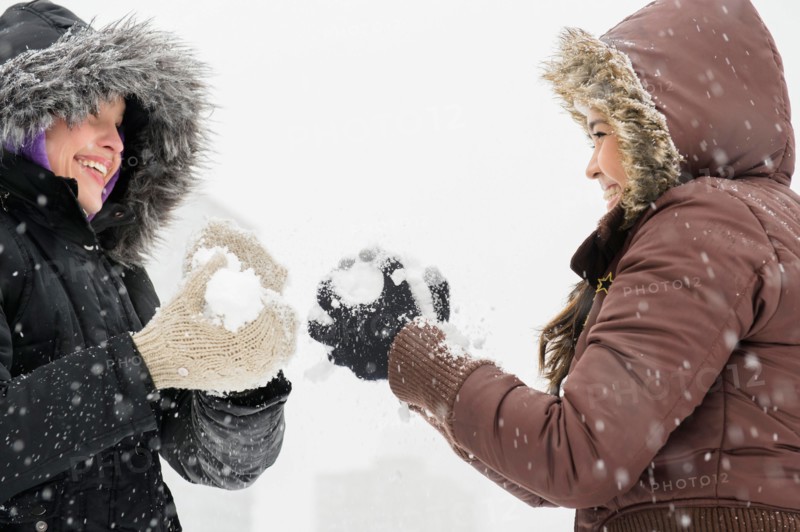 Two young women having snowball flight