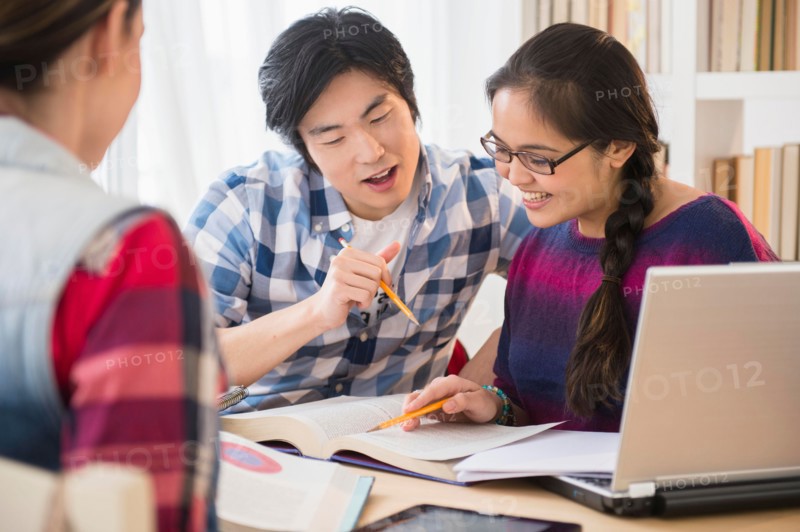 Young women and man studding in library
