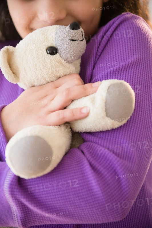 Girl (8-9) holding teddy bear