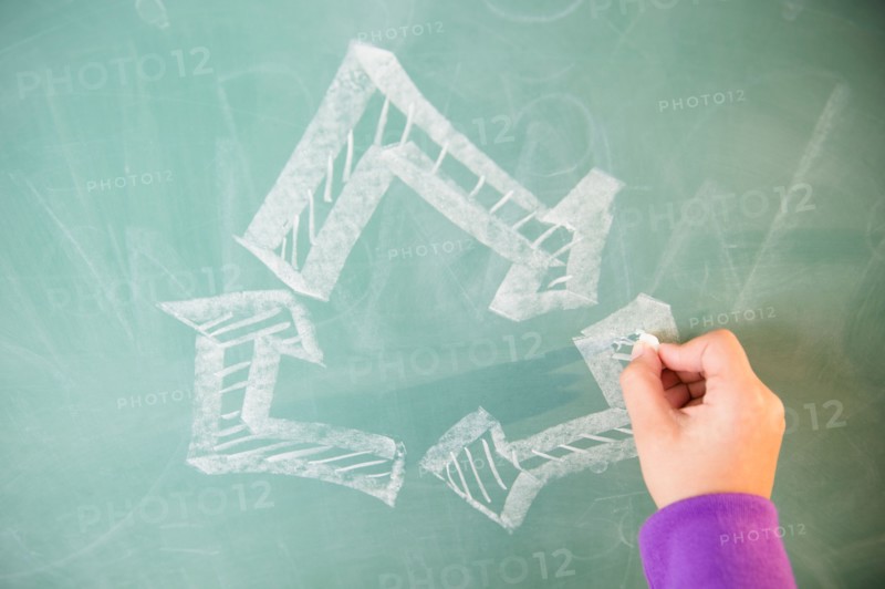 View of arrows on blackboard and girl's hand