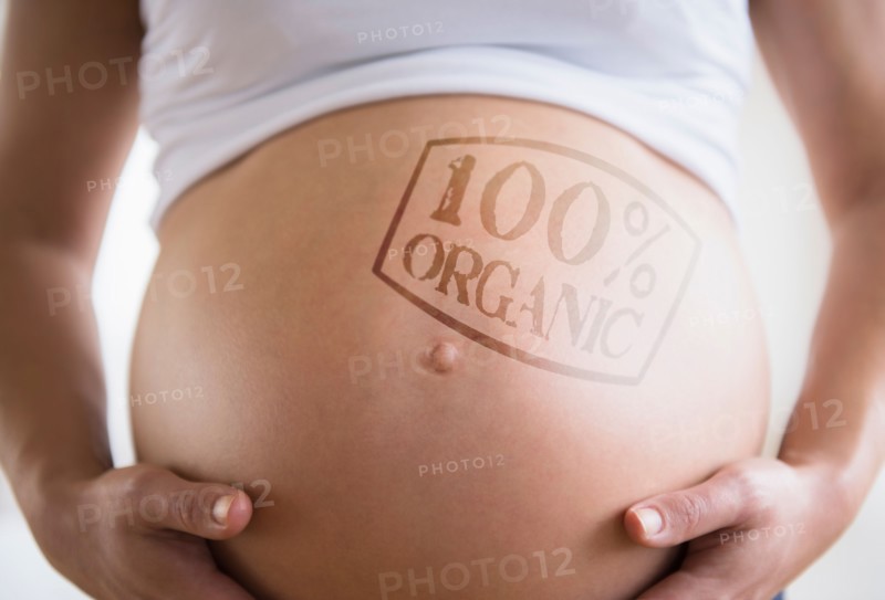 Mid section of pregnant woman with label on belly