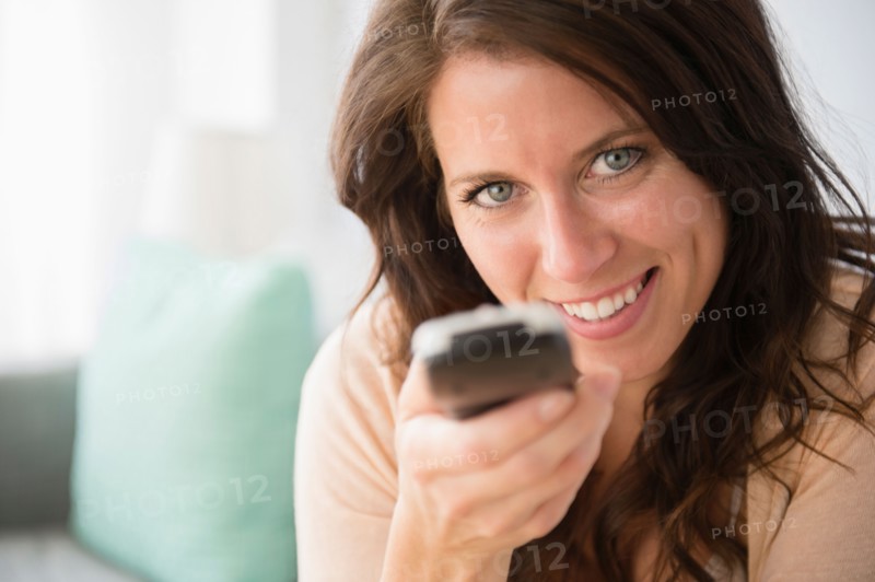 Young woman holding remote control