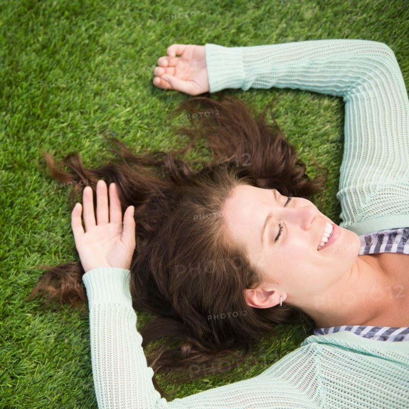 Happy woman lying on grass