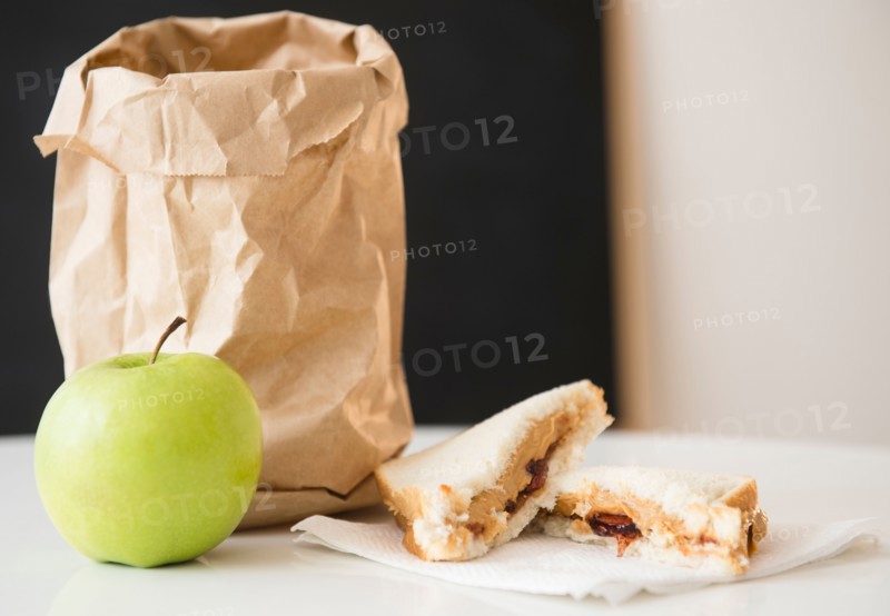 Studio Shot of green apple and sandwich next to paper bag
