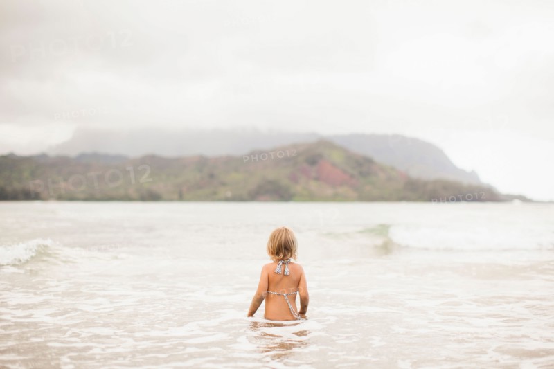 Baby girl (2-3) wading in ocean