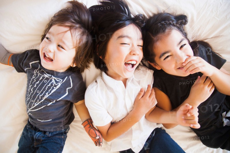 Portrait of siblings laying on bed