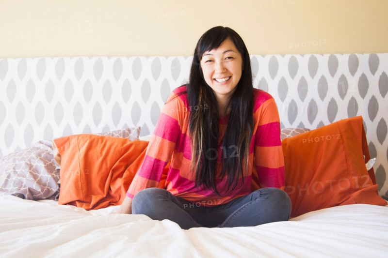 Portrait of mid adult woman sitting on bed