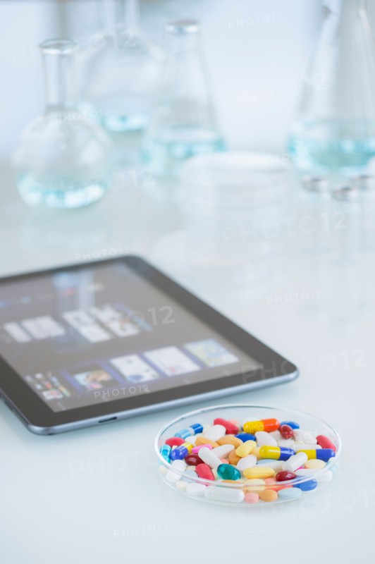 Studio shot of tablet pc and colorful pills.
