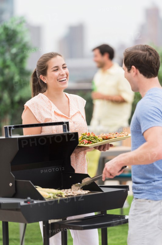 Friends enjoying barbecue in garden.