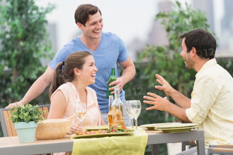 Friends enjoying barbecue in garden.