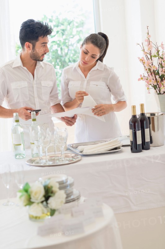 Business owners preparing dining table.