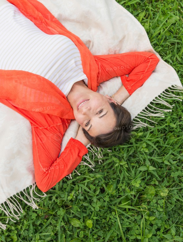 Mature woman lying on grass.