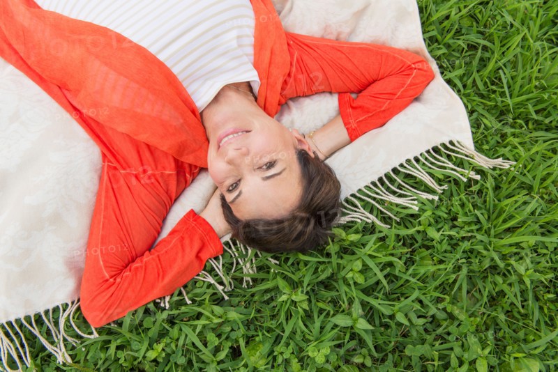 Mature woman lying on grass.
