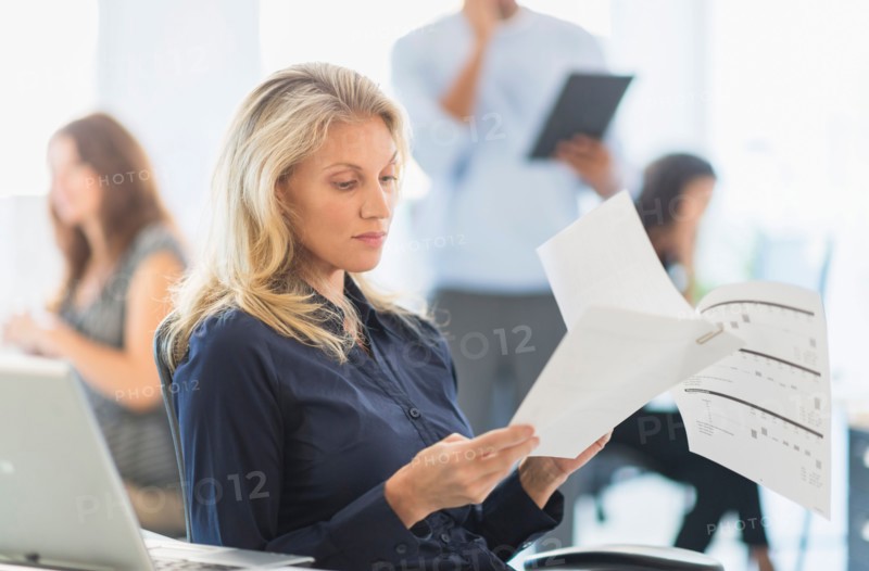 Woman reading at desk in office.
