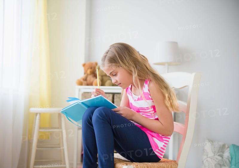 Girl (8-9) writing diary