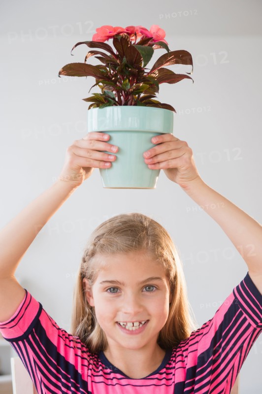Portrait of girl (8-9) holding flower pot