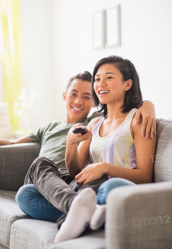 Young woman and young man sitting on sofa