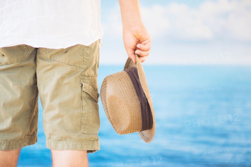 Studio Shot Rear view of man holding straw hat