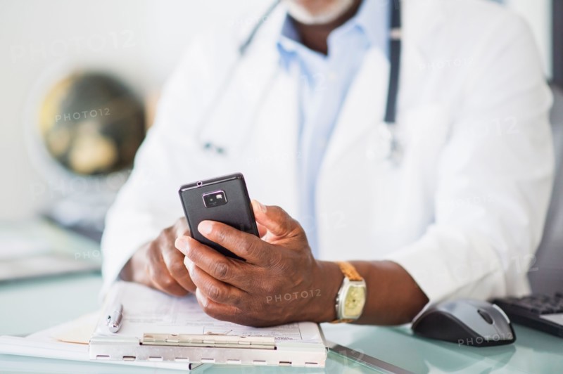 Close up of doctor's hand holding mobile phone