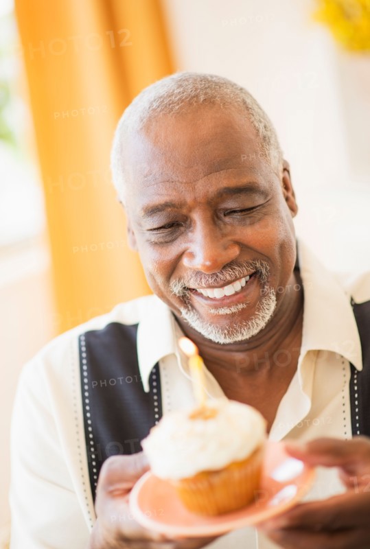 Portrait of man holding cupcake with candle