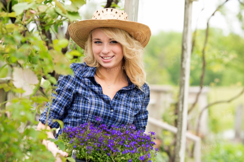 Portrait of young woman holding potted flowers