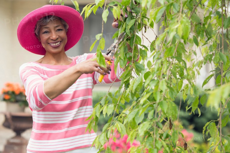 Portrait of senior woman pruning branch