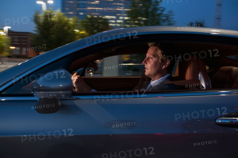 Profile of businessman driving car