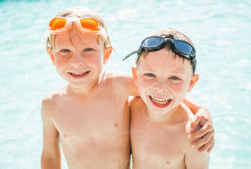 Two boys (4-5) playing in swimming pool