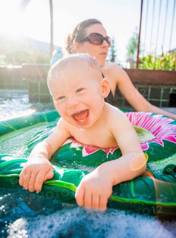 Baby boy (18-23 months) playing in swimming pool with his mother