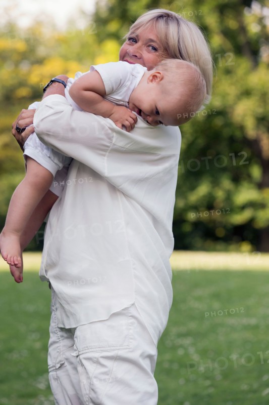 Grandmother carrying her granddaughter (12-17 months) on shoulder