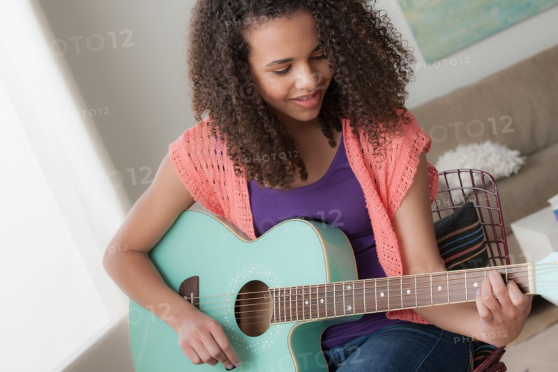 Girl (12-13) playing guitar