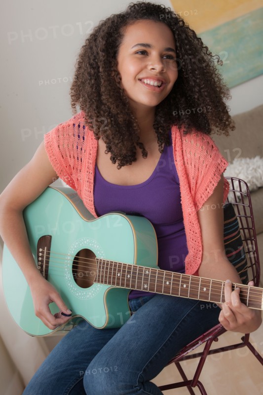 Girl (12-13) playing guitar