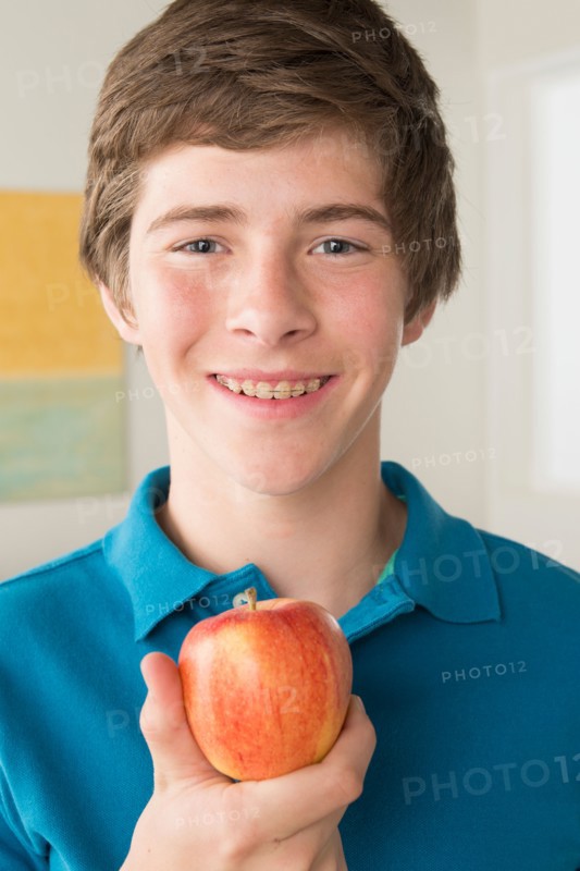 Boy (14-15) holding apple