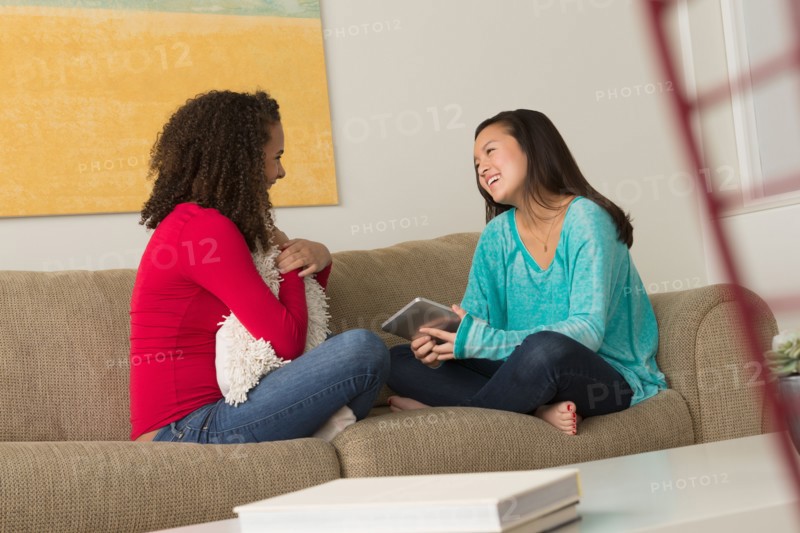 Two friends (12-13,16-17) sitting on sofa