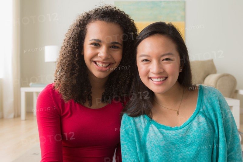 Two friends (12-13,16-17) sitting on sofa