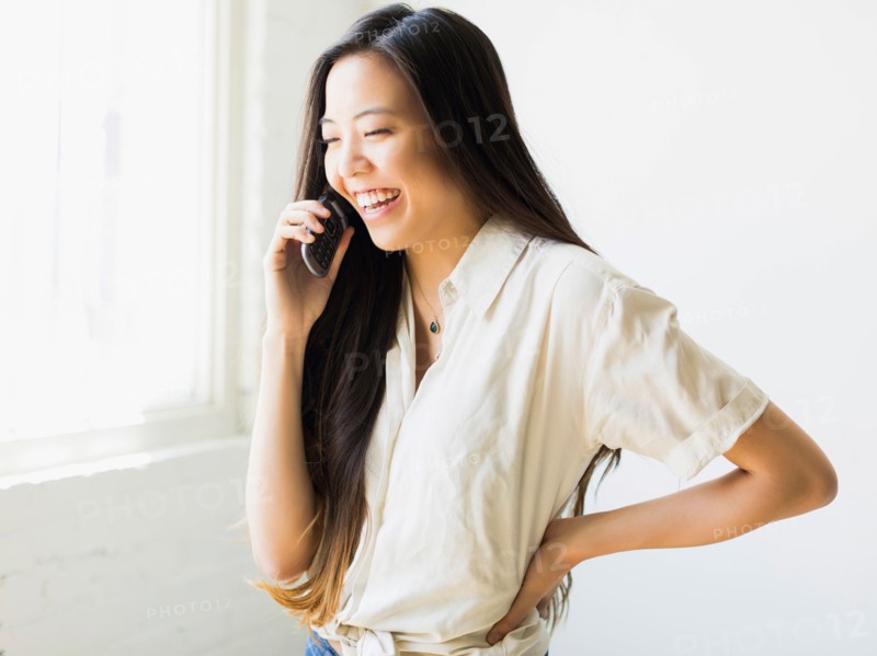 Smiling young woman talking via mobile phone
